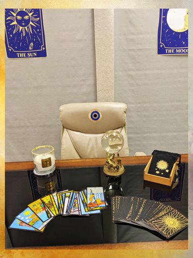 Tarot cards, Crystal ball and Candle displayed on a desk with tarot cards in the background 