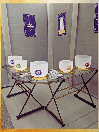 crystal singing bowls with charka symbols on a glass table