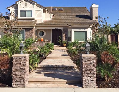 Stone steps up to a front door with a Southern California landscape