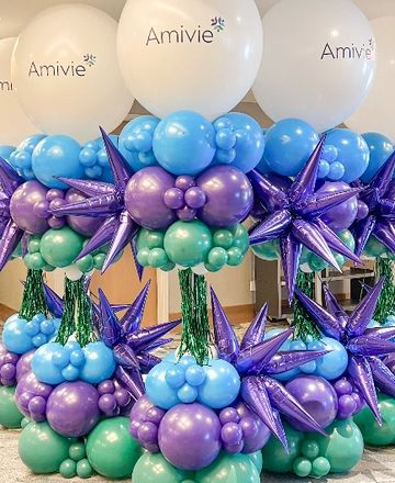 Colorful balloon arrangements with white Amivie-branded balloons on top.