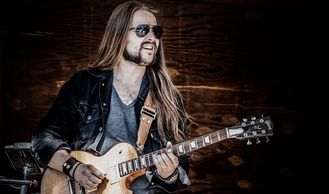 Sam looking very rock & roll in 2019, with his Les Paul and aviatos. Photo by Dennis Brooks Kelly.