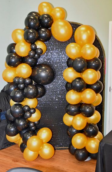 Balloon arch with black and gold balloons 