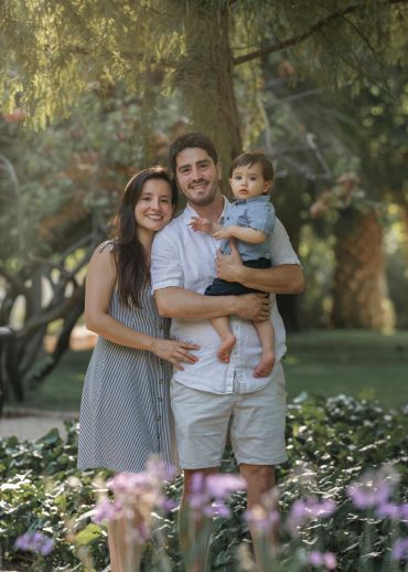 Familia feliz posando en un jardín.