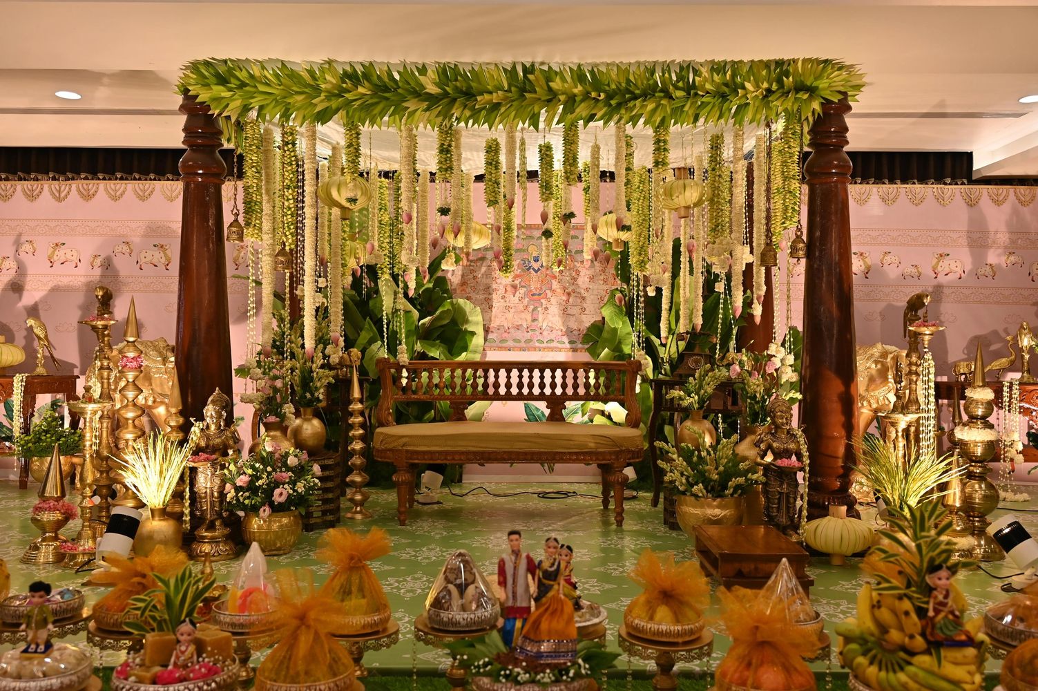 Traditional Indian wedding mandap decorated with flowers and brass statues.