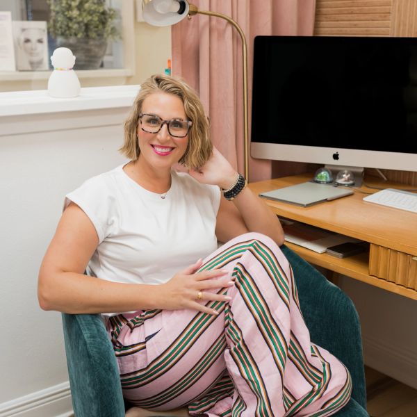 Smiling woman sitting comfortably in an office chair.