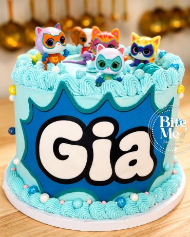 Blue themed cake with cat figurines and the name Gia.