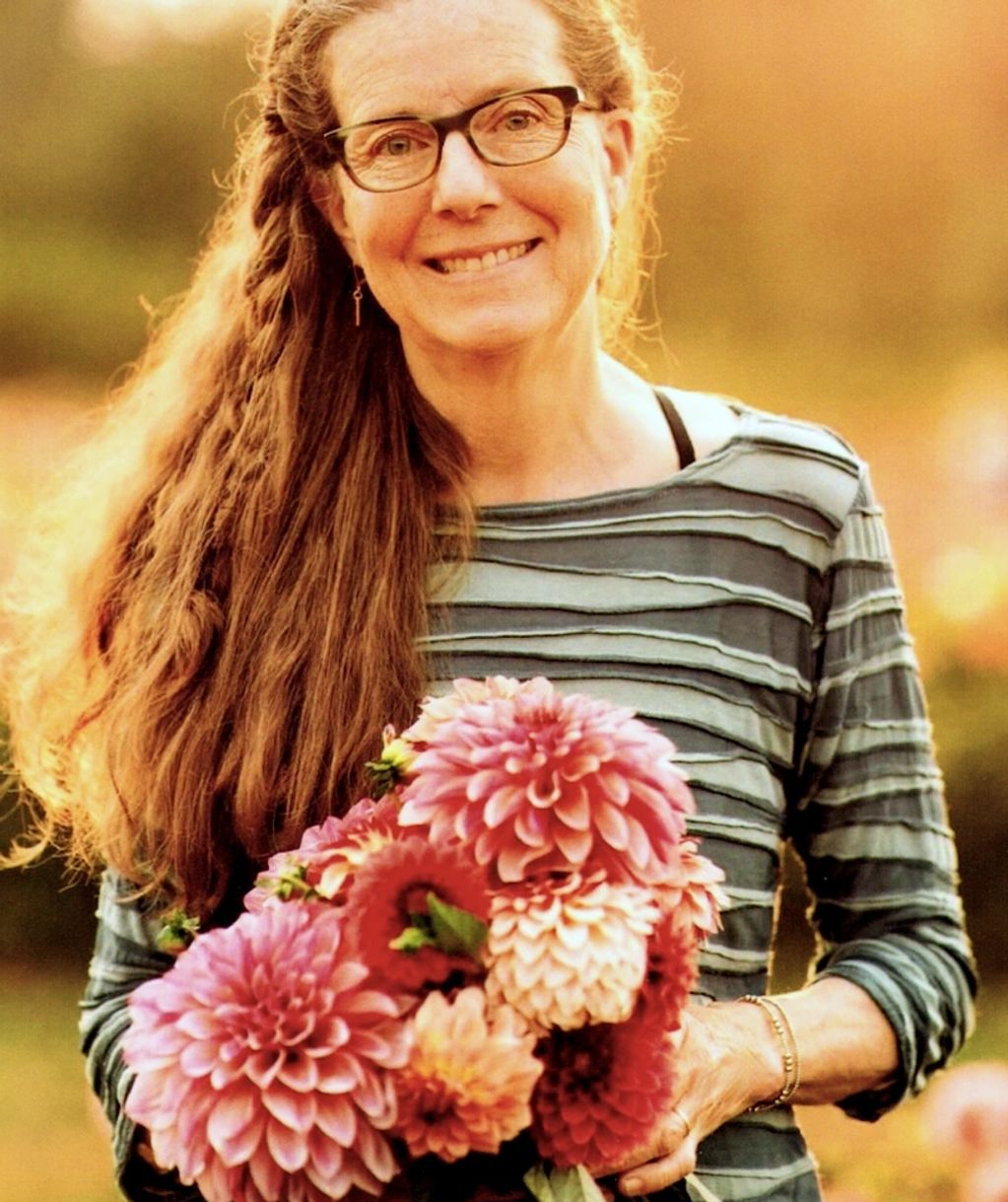 photo of Kristine Albrecht holding a bunch of dahlias