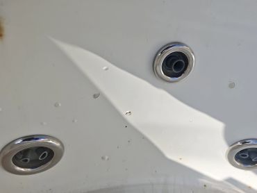 Close-up of three silver circular fixtures on a white surface.