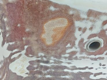 Ceiling with water damage and peeling paint around a light fixture.