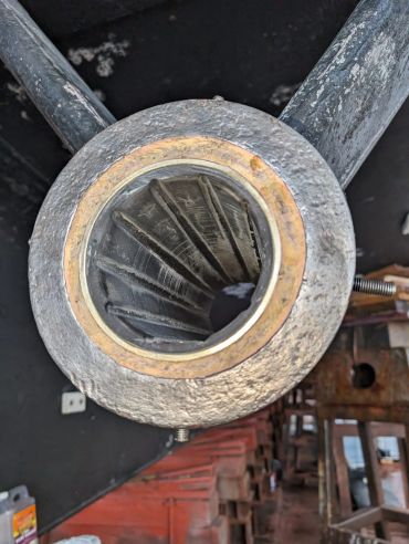 Close-up of a metallic, threaded pipe joint with a brass ring.