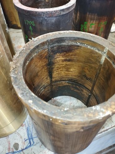 Large cylindrical metal pipes with worn interiors and markings.