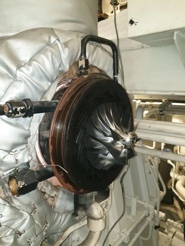 Close-up of a turbocharger inside an engine compartment.