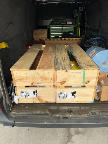 Wooden crates and various supplies loaded in a vehicle's cargo area.