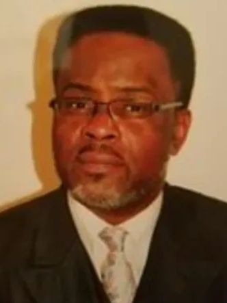 Man with glasses and beard in suit and tie.