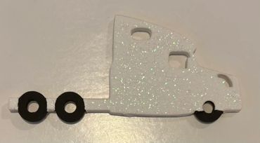Cab of semi truck that is white with white glitter and black tires