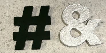A hashtag painted in matte black next to an ampersand painted in metallic white