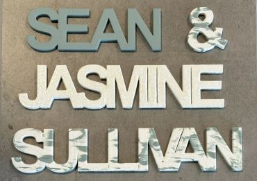 The name Sean in matte sage, an ampersand in matte sage and white, the name Jasmine in matte white w