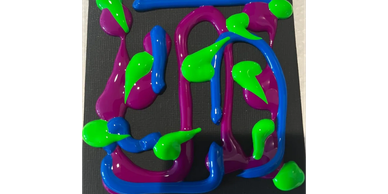 Bright paint splashes in green, blue, and purple on a black canvas.