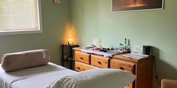 A room used for Reiki with a bed and green walls.
