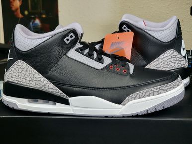 A pair of black and white Nike Air Jordan sneakers with elephant print details.