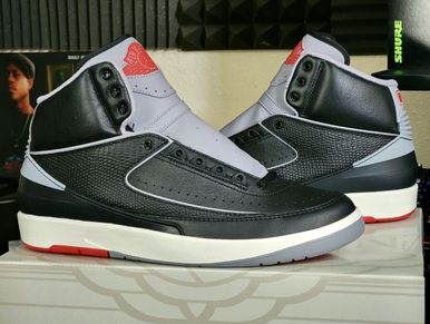 Black, white, and red high-top sneakers with textured detailing.