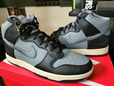 A pair of grey and black Nike high-top sneakers on a red box.