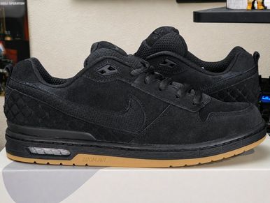 Black Nike sneakers with gum soles on display.