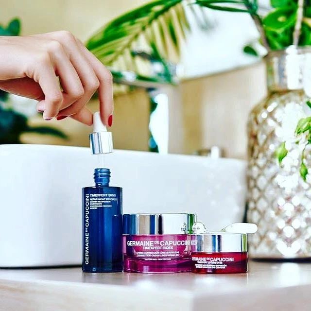 Germaine de Capuccini Timexpert skincare range, a hand holding a dropper with plants behind