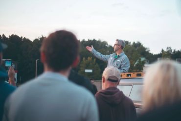 Man speaking to a crowd outdoors.