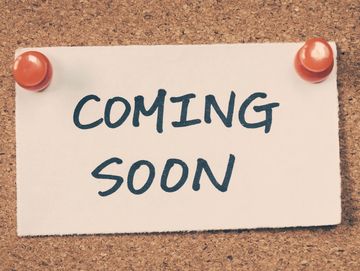 A note pinned to a cork board, the note reads "Coming Soon"