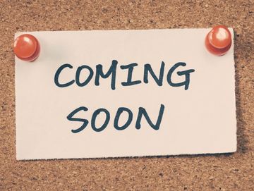 A note pinned to a cork board, the note reads "Coming Soon"