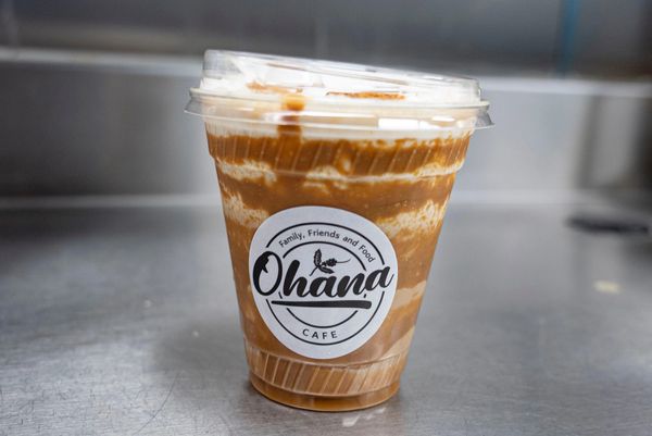 Iced coffee drink with cream in a clear plastic cup from Ohana Cafe.