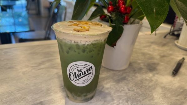 Iced matcha latte with cream and nuts on top at Ohana Cafe.