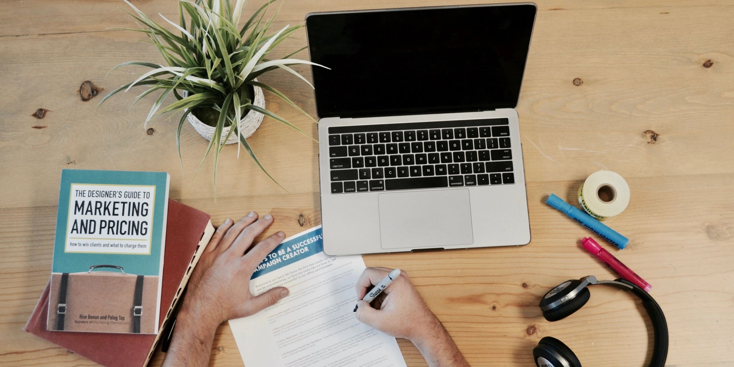 Worker at desk with Laptop and paper doing research for affiliate marketing.