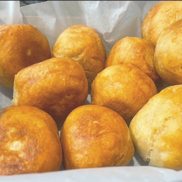 Golden brown bread rolls arranged closely together.