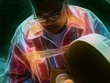 A person wearing glasses and a patterned shirt looking downward.