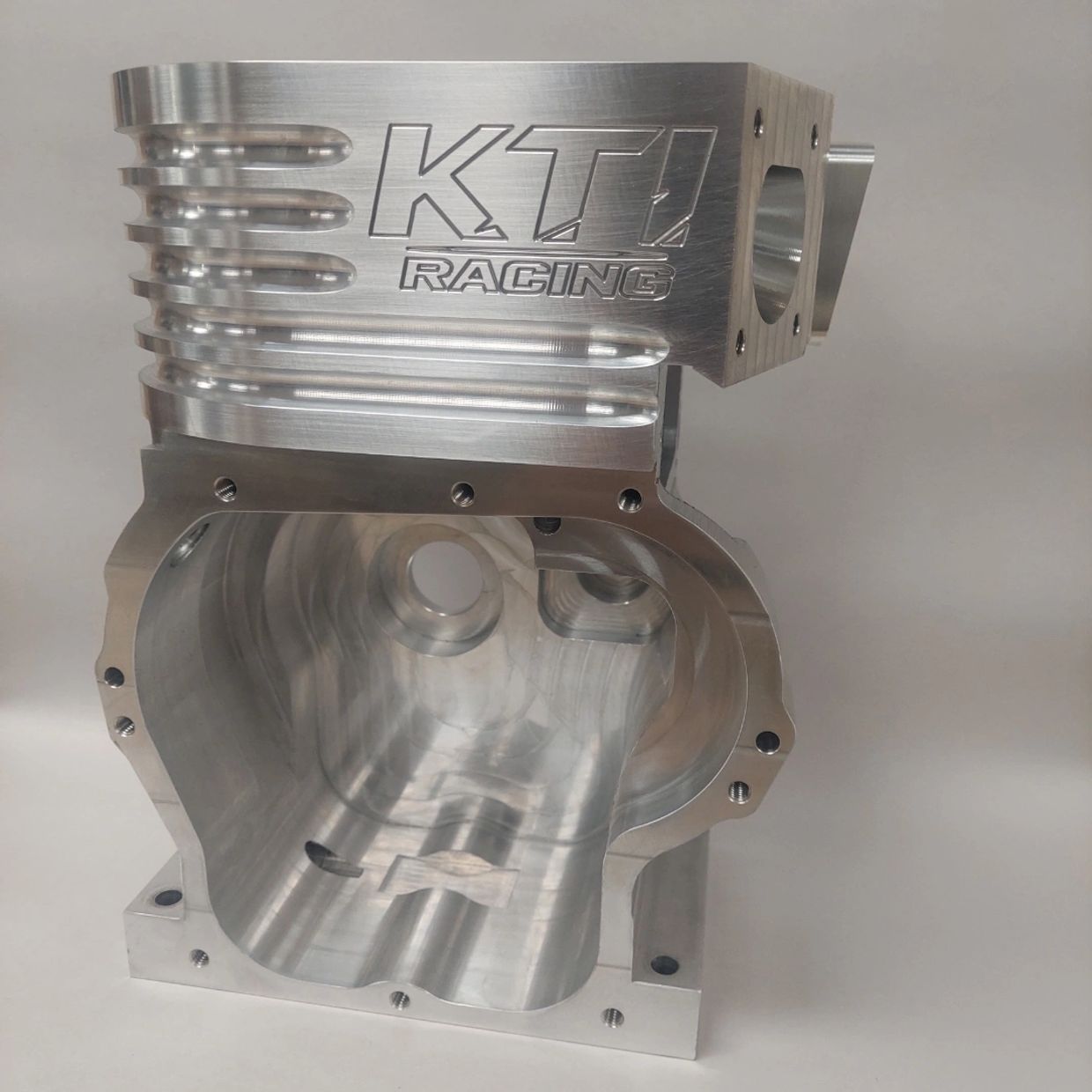Polished metal engine block with KTI Racing logo.