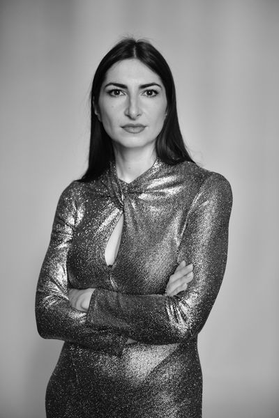 Femme en robe brillante avec les bras croisés.
