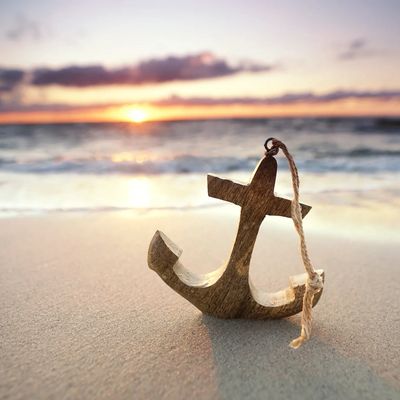 Anchor on a beach at sunset