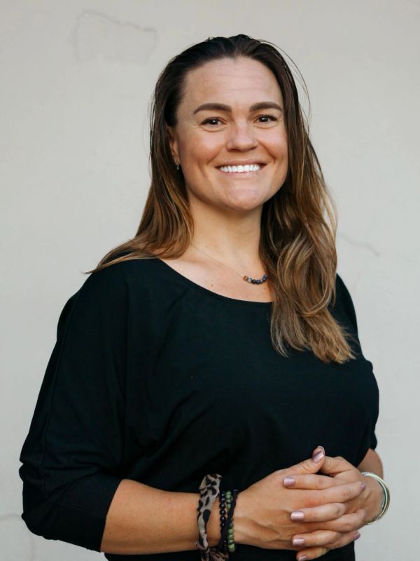 Smiling woman with long hair wearing a black top.