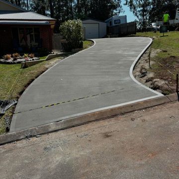 Newly poured concrete driveway outside a house.