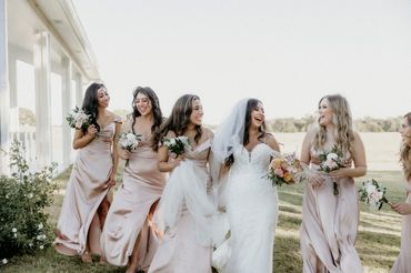 Bride and bridesmaids walking and laughing