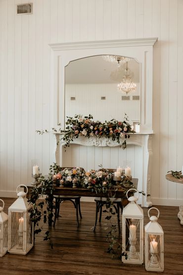 Wedding table setup with flowers and a fireplace behind