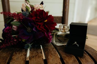 Flowers, perfume, and wedding ring on top of a chair