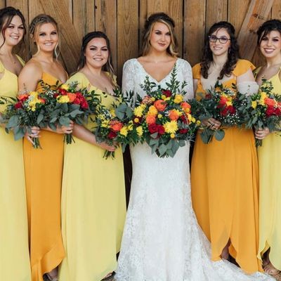 Bride and bridesmaids smiling and holding flowers