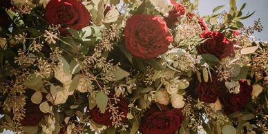 Wedding Arch flower arrangement with bridal dress hanging down