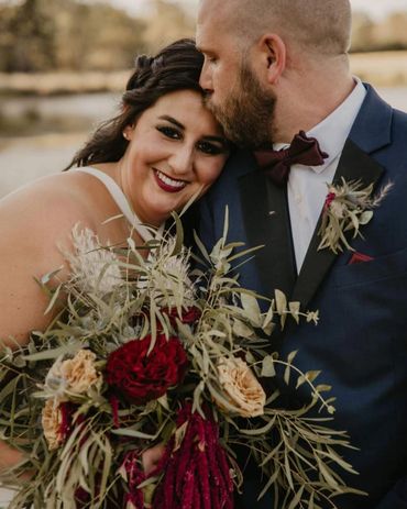 Groom kissing bride on forehead