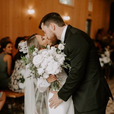 bride and groom kissing in front of a crowd