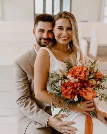 Bride and groom sitting and holding flowers