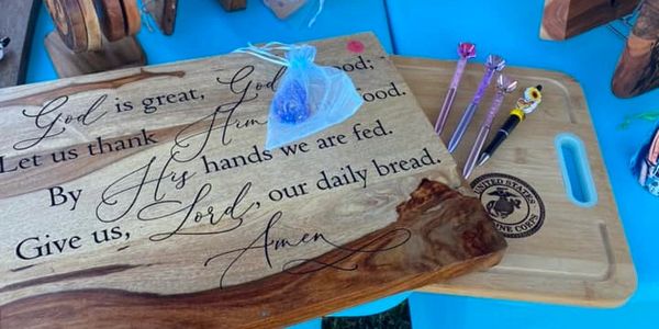 Wooden plaques with a religious quote and decorative pens on a blue table.